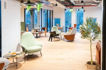 Dejvice cowork lounge s křesly a výhledem na Karlín